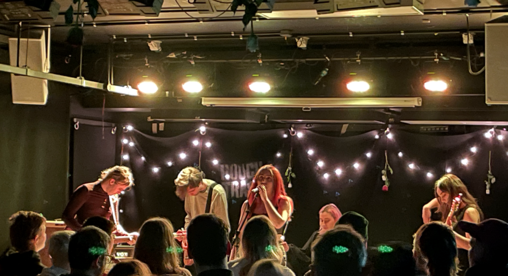 Five musicians from the band mhaol on a stage